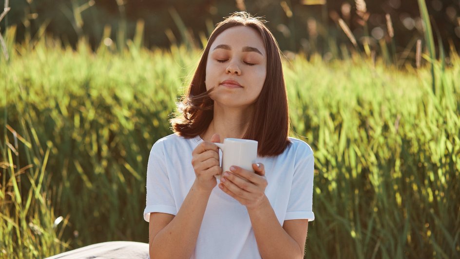 Женщина пьет гречишный чай на природе.
