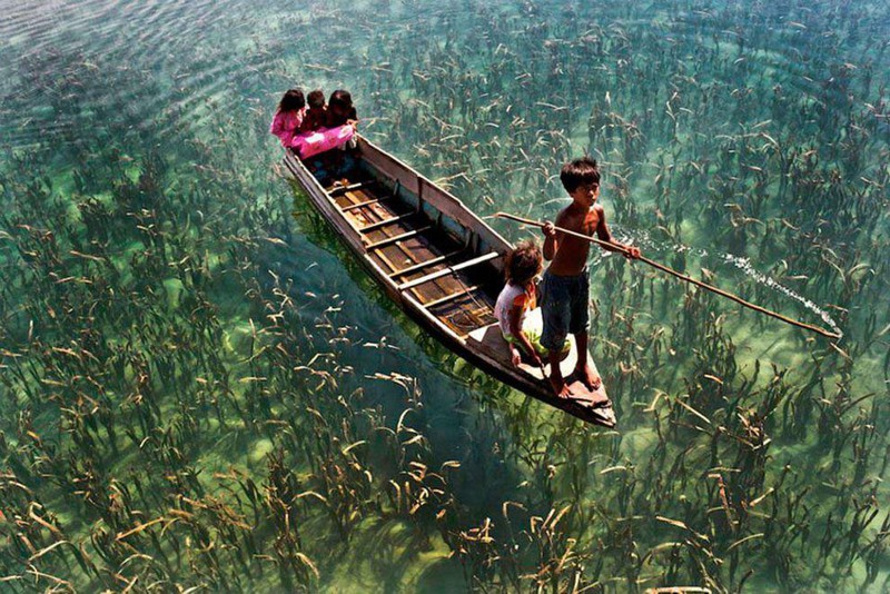 Дети катаются на лодке по кристально чистому озеру в Сабахе, Малайзия. без фотошопа, фото