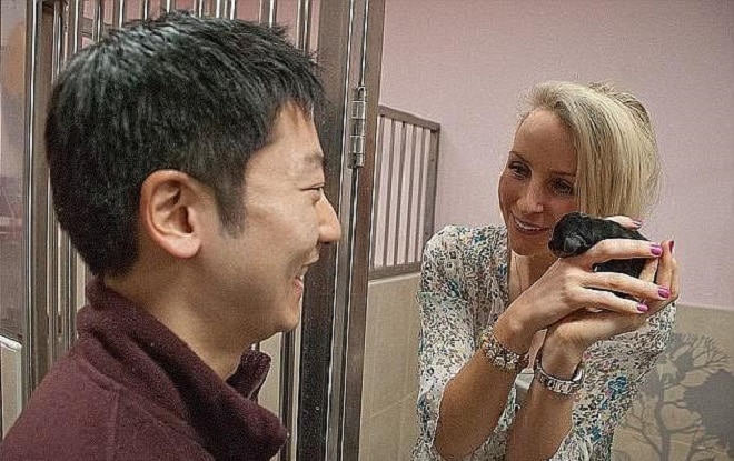 Женщина и щенок в руках Мужчина и женщина