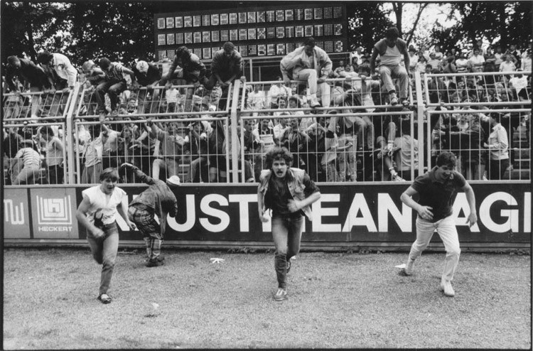 Хулиганы перескочили через забор и выбежали на поле по окончании напряженного футбольного матча винтаж, германия, люди, фото