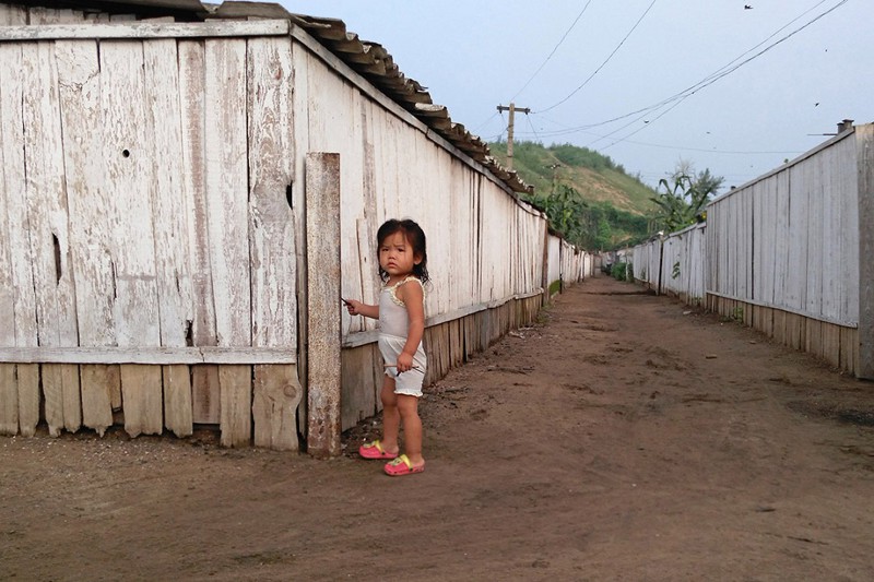 Маленькая девочка гуляет по улице в этом же городке жизнь, люди, путешествие, северная корея