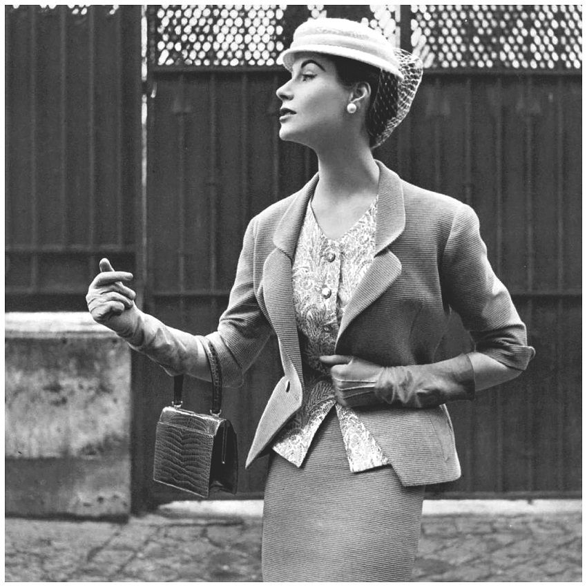 Myrtle Crawford in beige Ottoman suit with fitted jacket indented to v, worn over print cashmere top and narrow skirt by Manguin, hat by Paulette, croc bag by Morab.jpg Myrtle Crawford in beige Ottoman suit with fitted jacket indented to v, worn over print cashmere top and narrow skirt by Manguin, hat by Paulette, croc bag by Morab.jpg