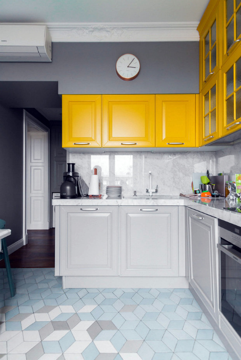 Бело-серая кухня с желтыми шкафчиками.