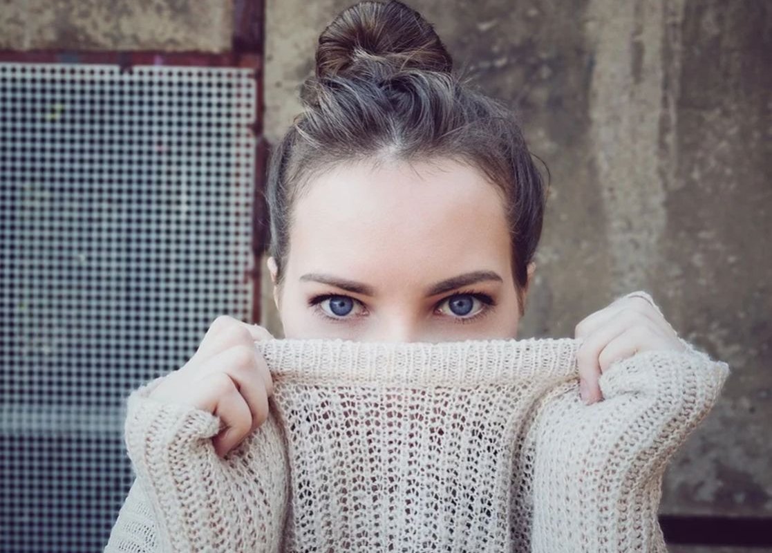 лицо девушки прикрыто свитером