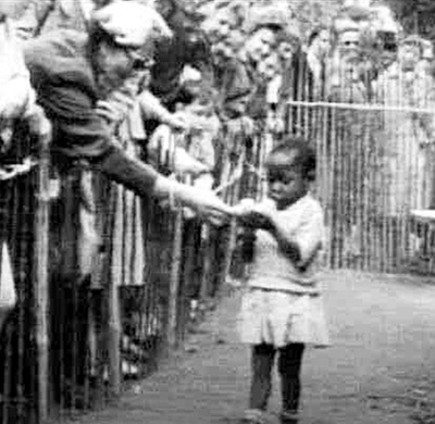 Бельгия, 1958 год. Африканскую девочку показывают в зоопарке. От посетителей отбоя нет, они несут ребёнку бананы, как обезьянке