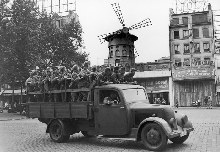 Немецкие солдаты проезжают мимо кабаре Мулен Руж. 8 августа 1940г.