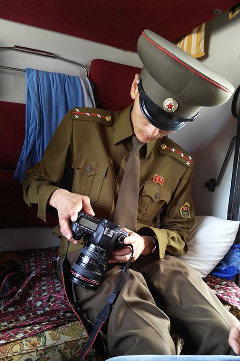 Офицер таможенной служды проверяет цифровую камеру пассажира в поезде, следующего из Москвы в Пхеньян жизнь, люди, путешествие, северная корея