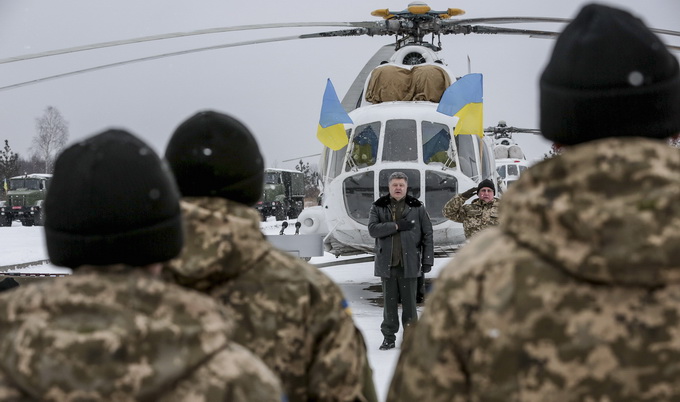 Ukrainian President Petro Poroshenko (C) listens to the state anthem as he visits the Yavoriv military range outside Lviv, western Ukraine, in this December 30, 2014 handout photo provided by the Ukrainian Presidential Press Service. REUTERS/Ukrainian Presidential Press Service/Mikhail Palinchak/Handout via Reuters (UKRAINE - Tags: POLITICS) ATTENTION EDITORS - THIS PICTURE WAS PROVIDED BY A THIRD PARTY. REUTERS IS UNABLE TO INDEPENDENTLY VERIFY THE AUTHENTICITY, CONTENT, LOCATION OR DATE OF THIS IMAGE. THIS PICTURE IS DISTRIBUTED EXACTLY AS RECEIVED BY REUTERS, AS A SERVICE TO CLIENTS. FOR EDITORIAL USE ONLY. NOT FOR SALE FOR MARKETING OR ADVERTISING CAMPAIGNS. THIS IMAGE HAS BEEN SUPPLIED BY A THIRD PARTY. IT IS DISTRIBUTED, EXACTLY AS RECEIVED BY REUTERS, AS A SERVICE TO CLIENTS