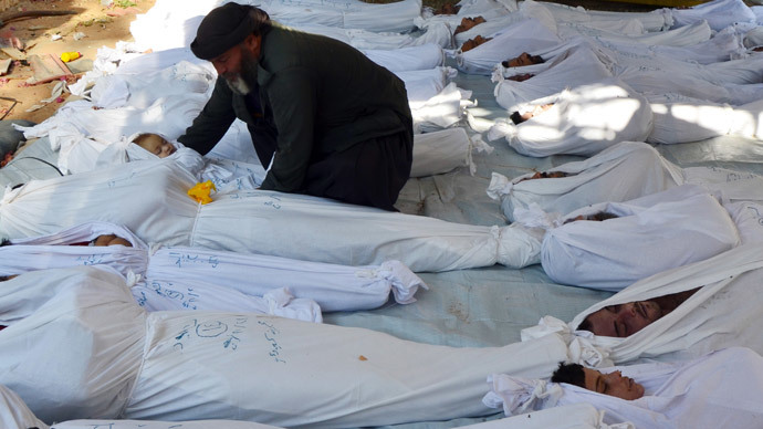 A man holds the body of a dead child among bodies of people activists say were killed by nerve gas in the Ghouta region, in the Duma neighbourhood of Damascus August 21, 2013.(Reuters / Bassam Khabieh)