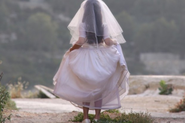 Девочка-подросток в подвенечном платье, вид сзади