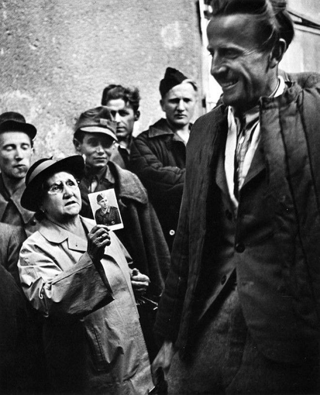16. Мать показывает фотографию своего сына освобожденному заключенному после окончания Второй Мировой Войны 16 Мать показывает фотографию своего сына освобожденному заключенному после окончания Второй Мировой Войны война история память