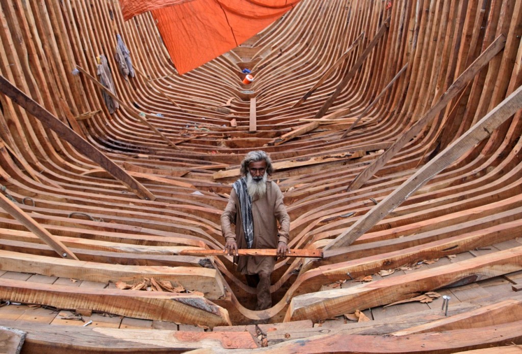 Плотник строит рыболовецкое судно в порту Карачи. Фото: AP