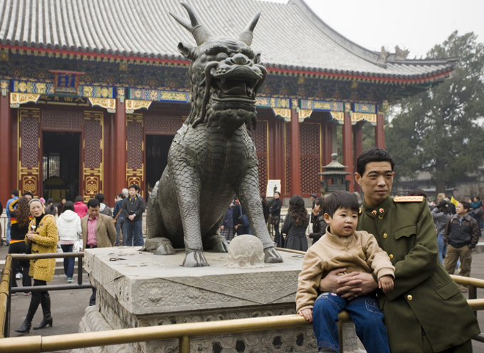Китайские граждане фотографируются на фоне скульптуры цилиня — существа, которое иногда имело один рог и обладало магическими свойствами.