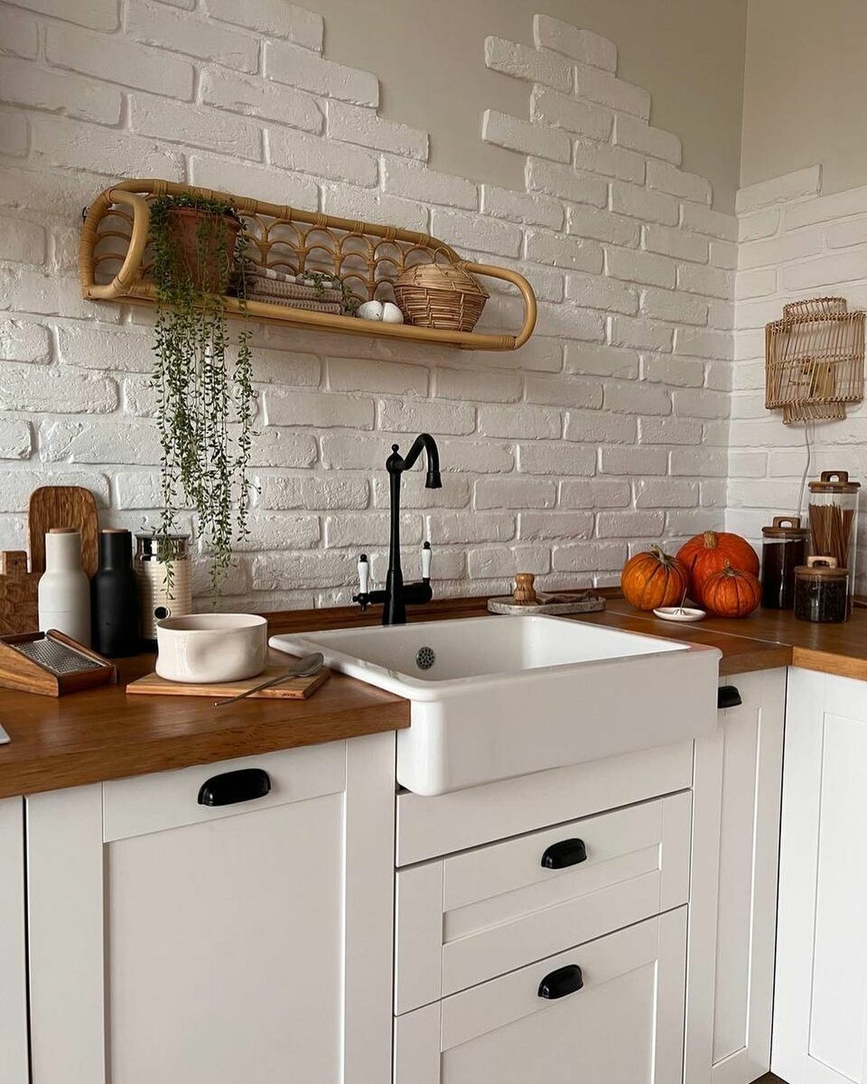 Белый кухонный гарнитур с деревянной столешницей — настоящая классика скандинавского интерьера. Очень стильно смотрится на фоне белого кирпича