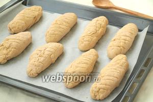 Застелить пергаментом противень и из каждого кусочка скатать хлебец. По верху сделать ножом надрезы.