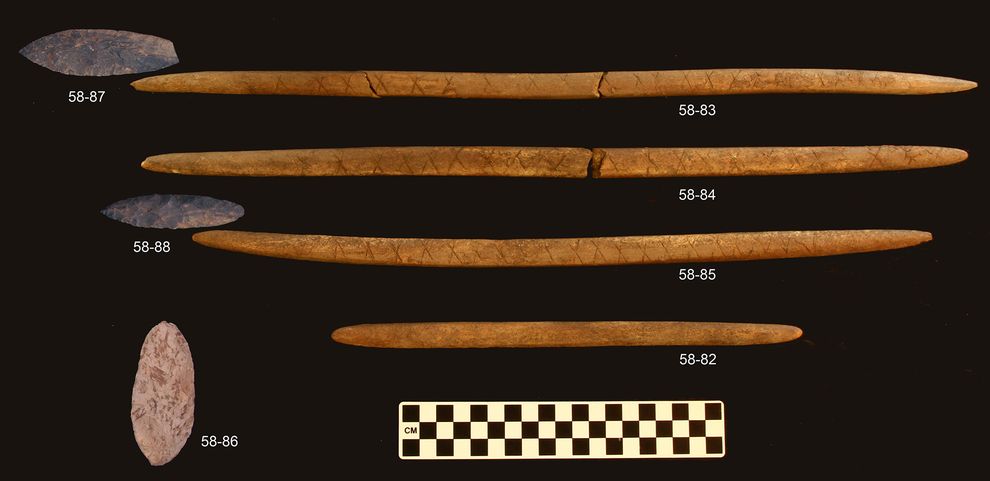 Stone projectile points and associated decorated antler foreshafts from the burial pit at the Upward Sun River site.