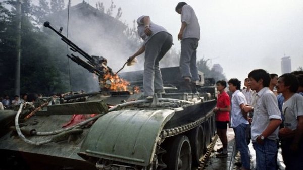 Протестующие осматривают уничтоженный танк