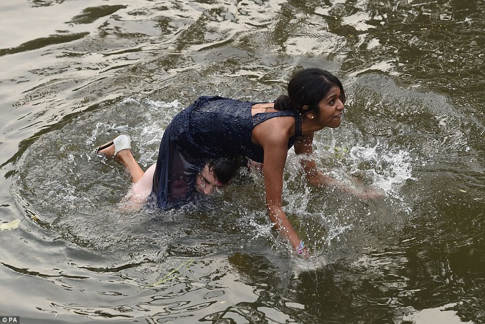 One woman fell head-first into the water after attempting to clamber onto her male companion's shoulders