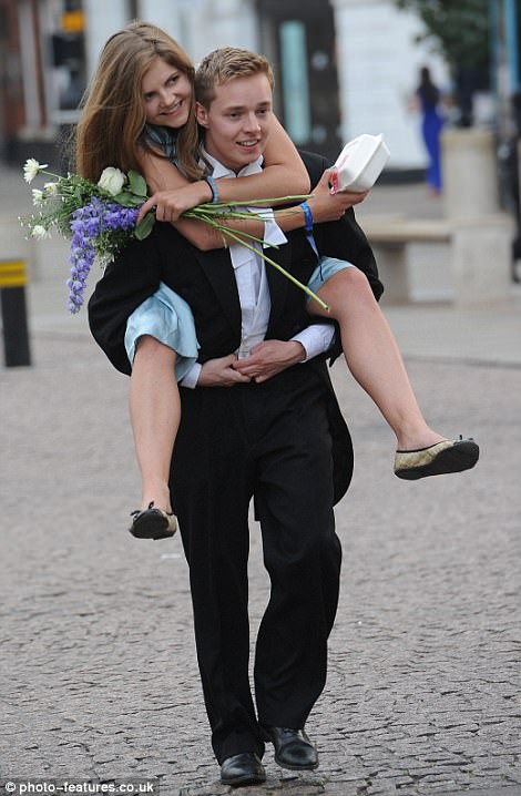 Clutching a box of takeaway food, one guest is given a lift from her male companion after partying the night away