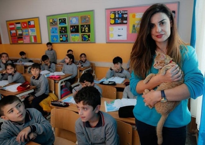 Учительница держит кота Кот на руках