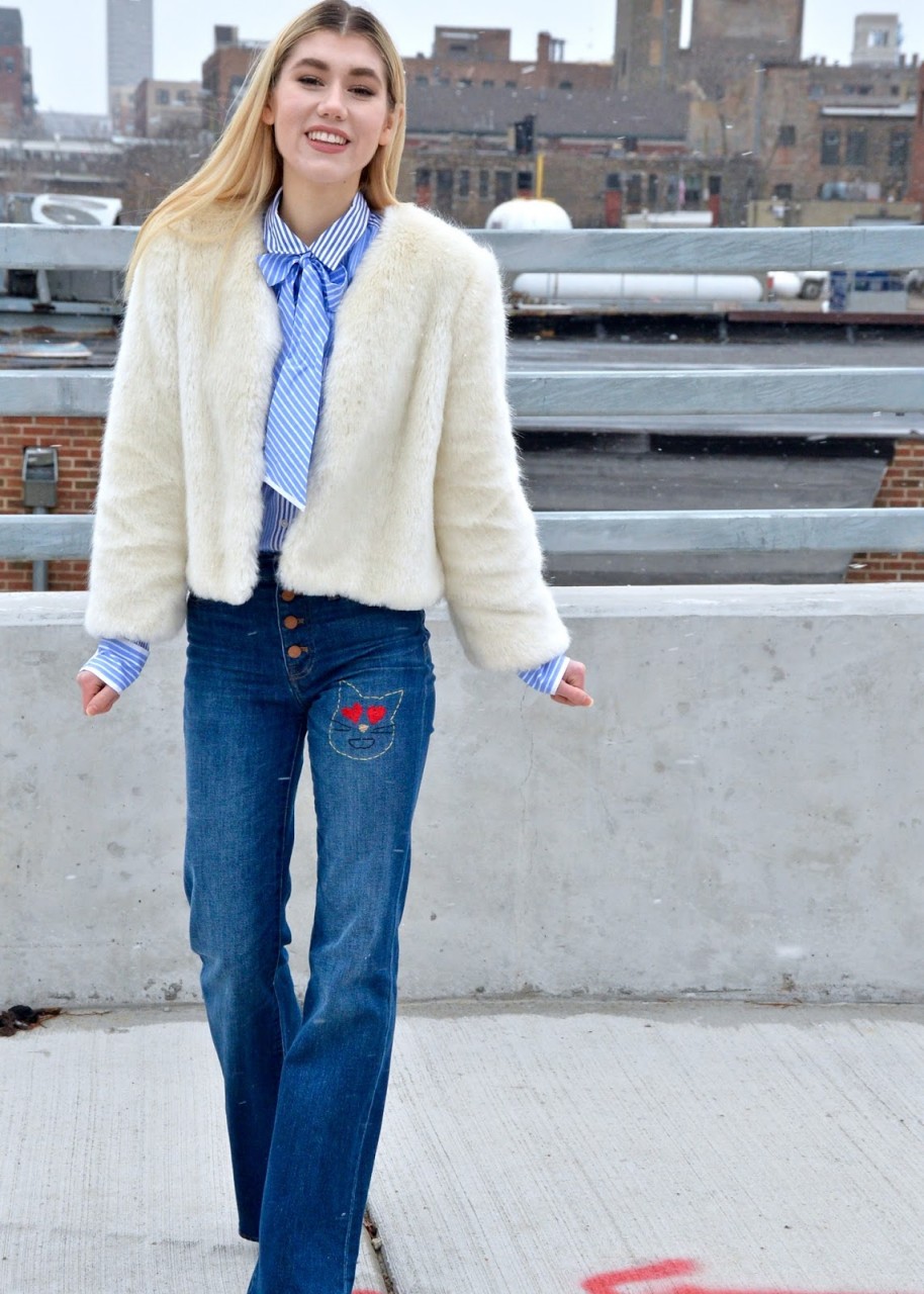 Woman wearing DIY Embroidered jeans with a button up shirt and a faux fur coat