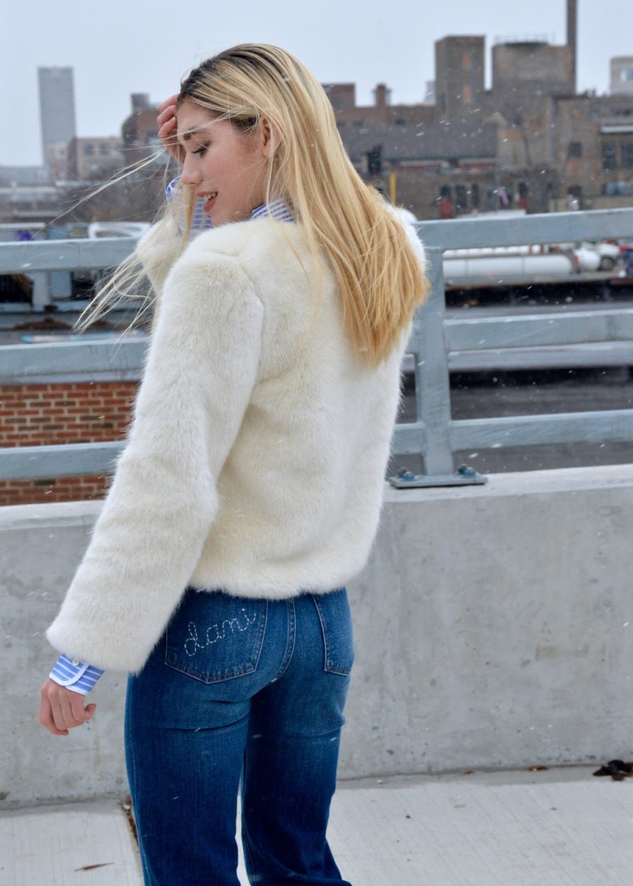 Fashion Blogger laughing in a white faux fur coat
