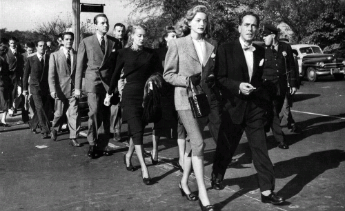 Активисты Комитета Первой поправки во главе с Лорен Бэколл и Хамфи Богатом направляются к зданию Палаты представителей, чтобы вручить ноту протеста, 1947
