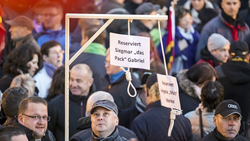 Demonstranten von Pegida halten Galgen mit Politikernamen bei einer Kundgebung in Dresden im Oktober 2015 hoch.