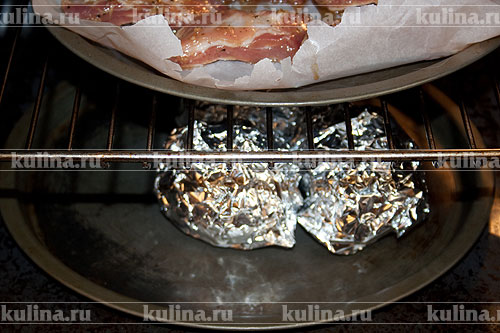 Завернуть картофель в фольгу. Переложить в огнеупорное блюдо. Запекать в разогретой до 200 градусов духовке почти до готовности.