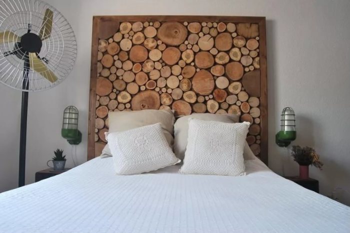 Декор изголовья кровати при помощи деревянных спилов. 