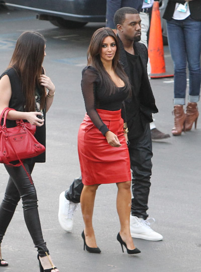 Ким Кардашьян в красной юбке и черной блузке