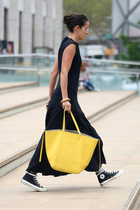 Девушка в черном макси платье, кеды и желтая большая сумка