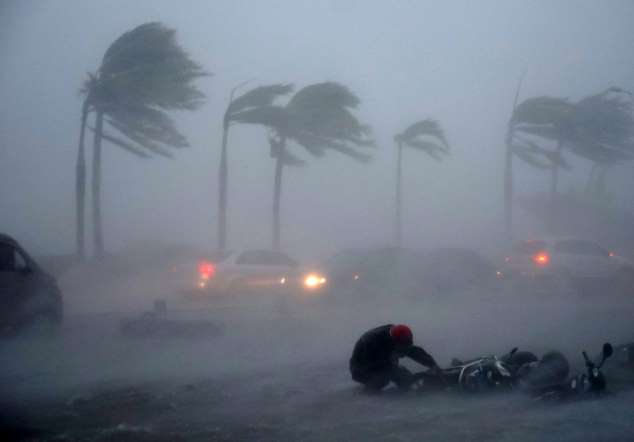 A man is blown down by typhoon Rammasun on July 18, 2014.  Typhoon Rammasun made landfall in Hainan Island and packed winds of up to 216 km per hour.