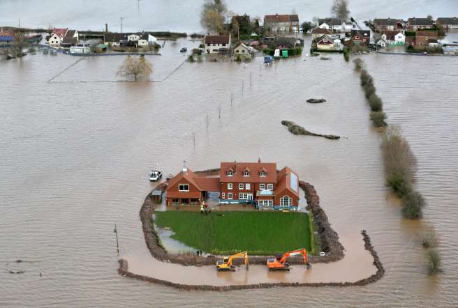 Worker's continue to build flood defenses around Moorland resident Sam Notaro's house in the flooded village of Moorland near Bridgwater on the Somerset Levels on February 10, 2014.