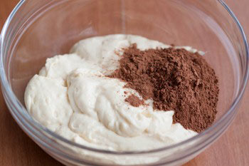 Добавить просеянное какао в миску с другой половиной теста