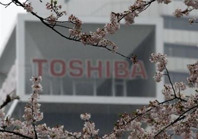 The logo of Toshiba Corp is seen behind cherry blossoms at the company's headquarters in Tokyo, Japan April 11, 2017. REUTERS/Toru Hanai