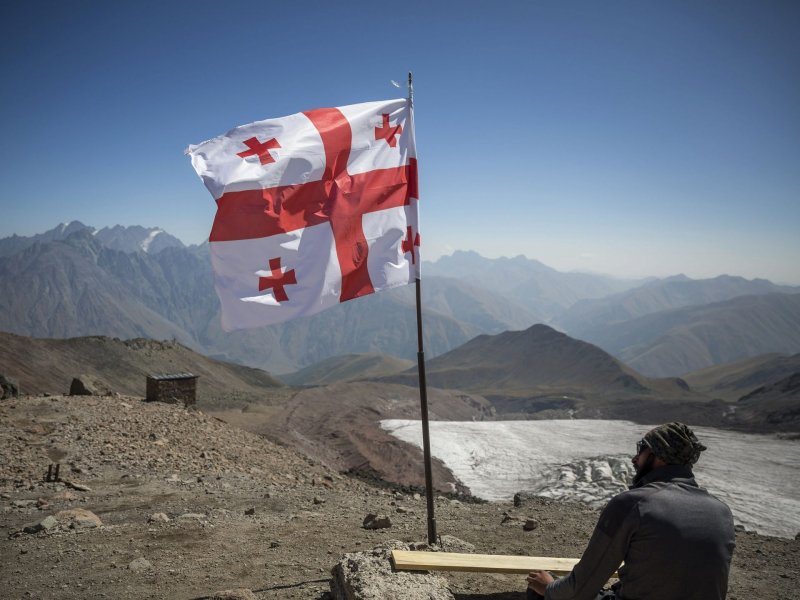 Альпинист отдыхает под флагом Грузии по пути к вершине горы Казбек, 14 сентября 2017 года. гора, горы, грузия, кавказ, казбек, красота, природа, фото