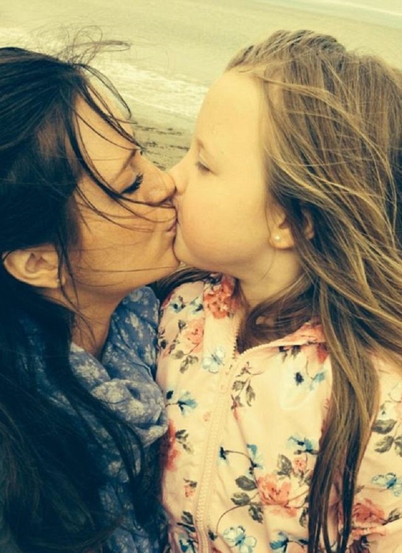 Mom kissing daughter