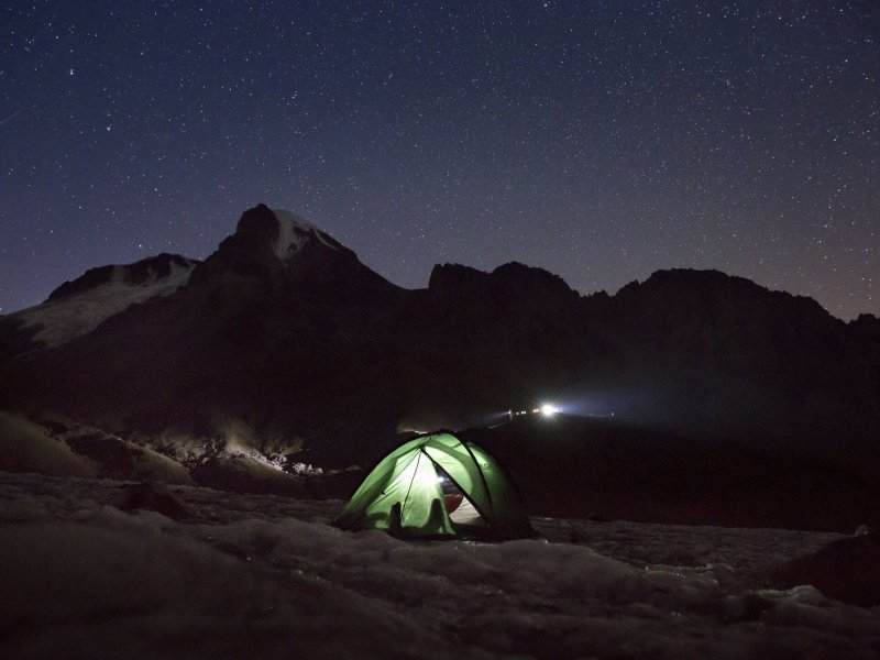 Огонёк уютно светится в палатке, установленной под ночным небом на пути к вершине горы Казбек, 13 сентября 2017 года. гора, горы, грузия, кавказ, казбек, красота, природа, фото