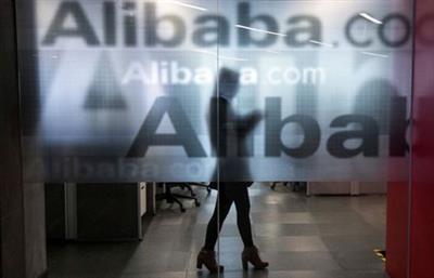 An employee is seen behind a glass wall with the logo of Alibaba at the company's headquarters on the outskirts of Hangzhou, Zhejiang province, April 23, 2014. REUTERS/Chance Chan/File Photo