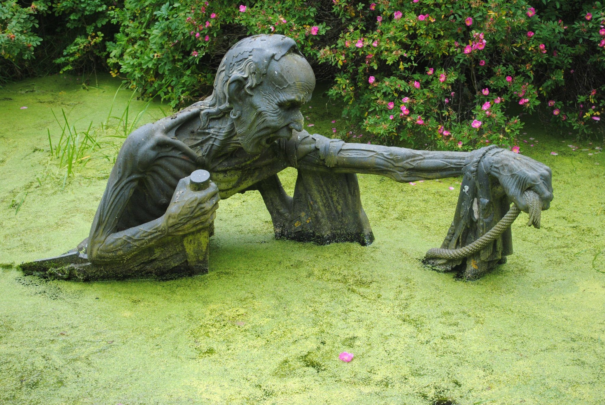 Резвится в саду около бронзовой скульптуры