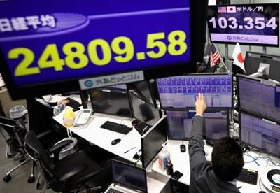 An employee of the foreign exchange trading company works in front of monitors showing Japan's Nikkei share average and the Japanese yen exchange rate against the U.S. dollar at a dealing room in Tokyo, Japan November 9, 2020. REUTERS/Issei Kato