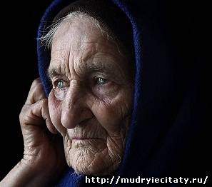 В больничной переполненной палате Стоит старушка, плачет у окна.
