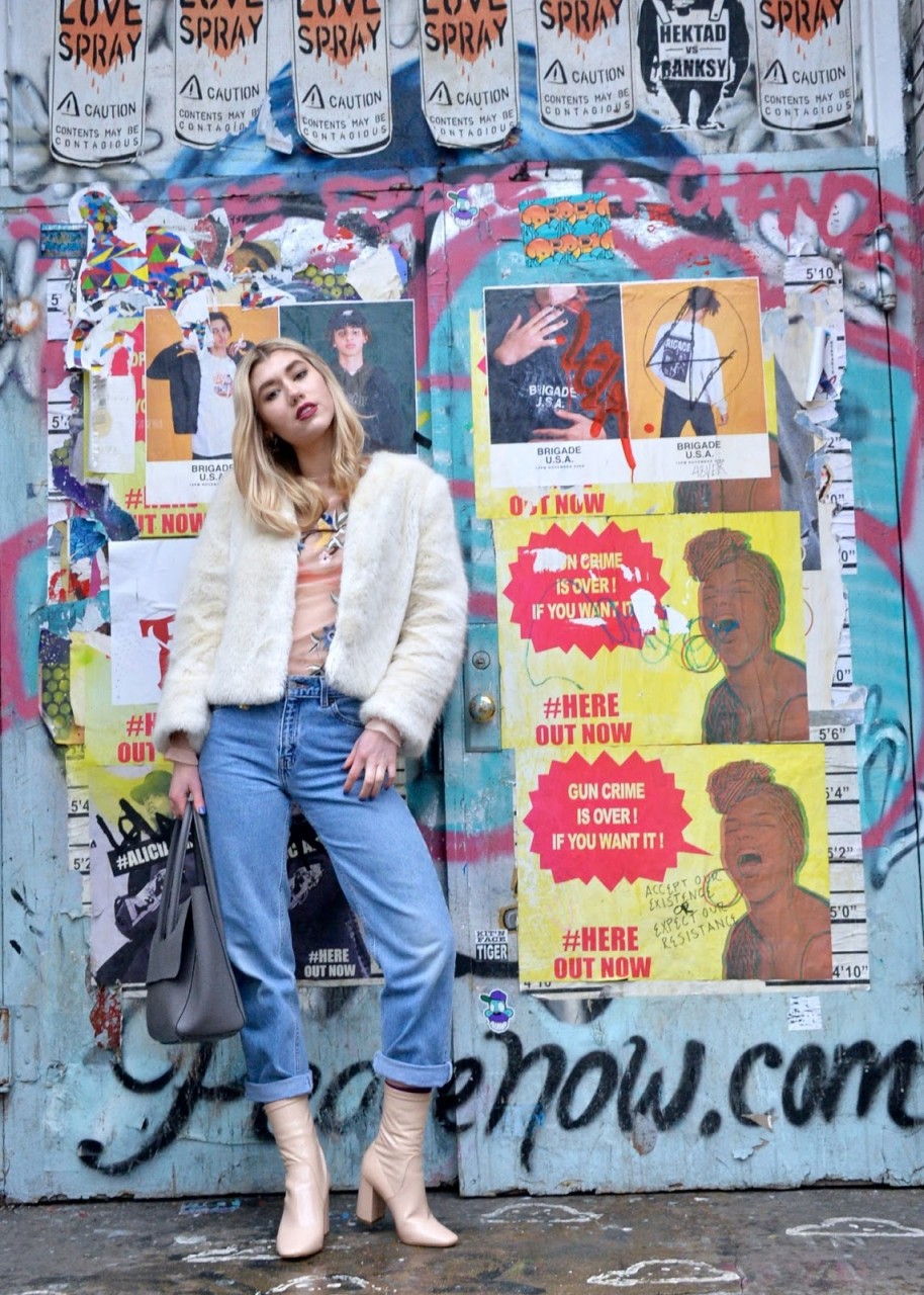 New York Fashion Week Street Style look wearing a nude top, fur coat, and vintage jeans
