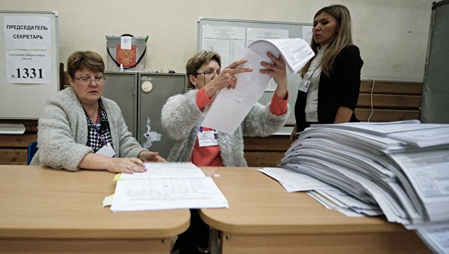 Члены избирательной комиссии во время подсчета голосов на избирательном участке. Члены избирательной комиссии во время подсчета голосов на избирательном участке.