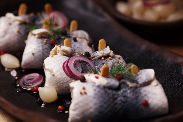 Rolled herring in vinegar, served with onions and pickles.