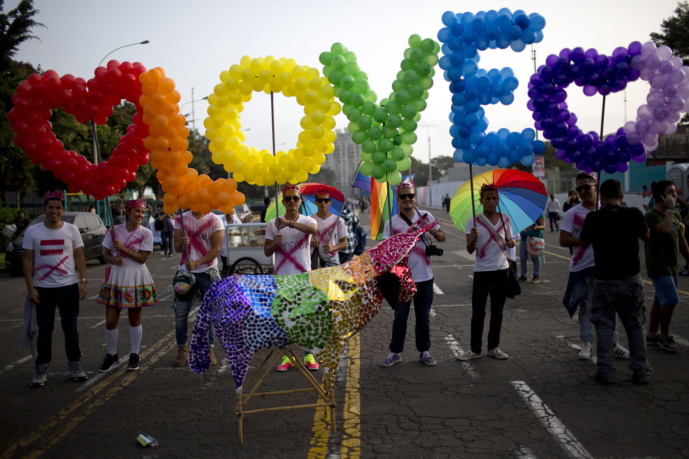 AP Peru Gay Pride Parade Revelers hold balloons, representing the colors of a rainbow, to form the word, "Love" during the annual gay pride parade in Lima, Peru, Saturday, June 27, 2015. (AP Photo/Rodrigo Abd) ORG XMIT: ABD107