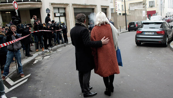 Люди стоят возле офиса издания Charlie Hebdo в Париже. Архивное фото