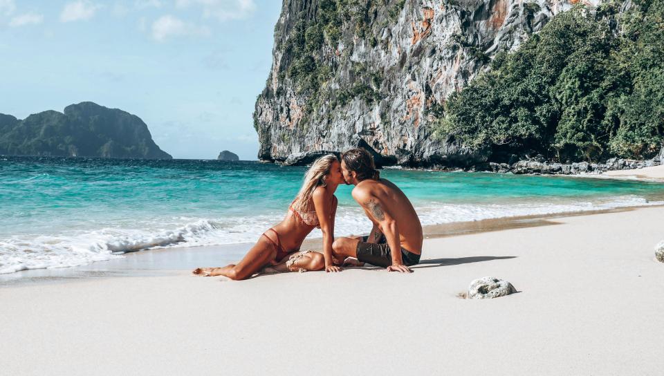 Молодая пара голой стоит на общественном пляже фото