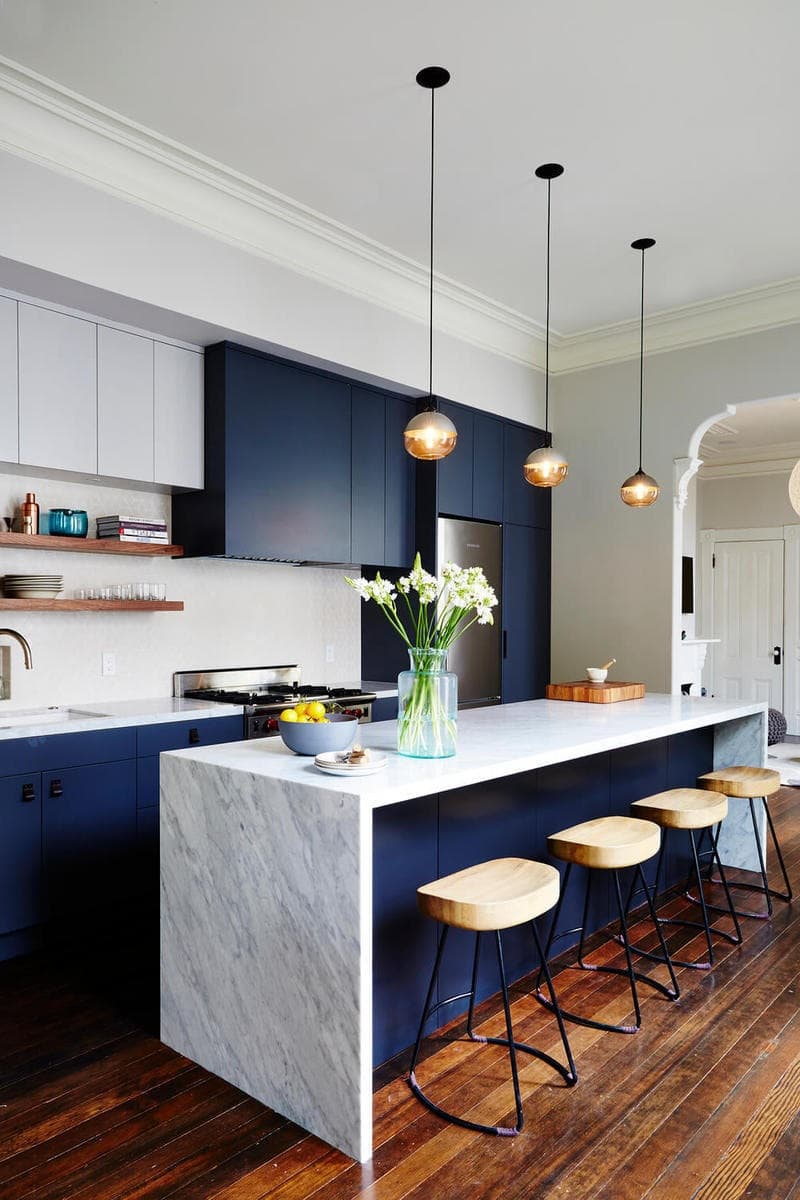 Глубокий синий часто используется в кухонных интерьерах в сочетании с белым мрамором. Этот тандем уже давно зарекомендовал себя с лучшей стороны.